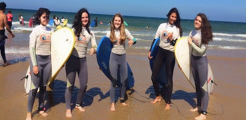 Grupo de amigas preparadas para coger olas en los campamentos